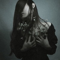 前髪で顔を隠すように俯く、悲しい気持ちを抱く女性の写真