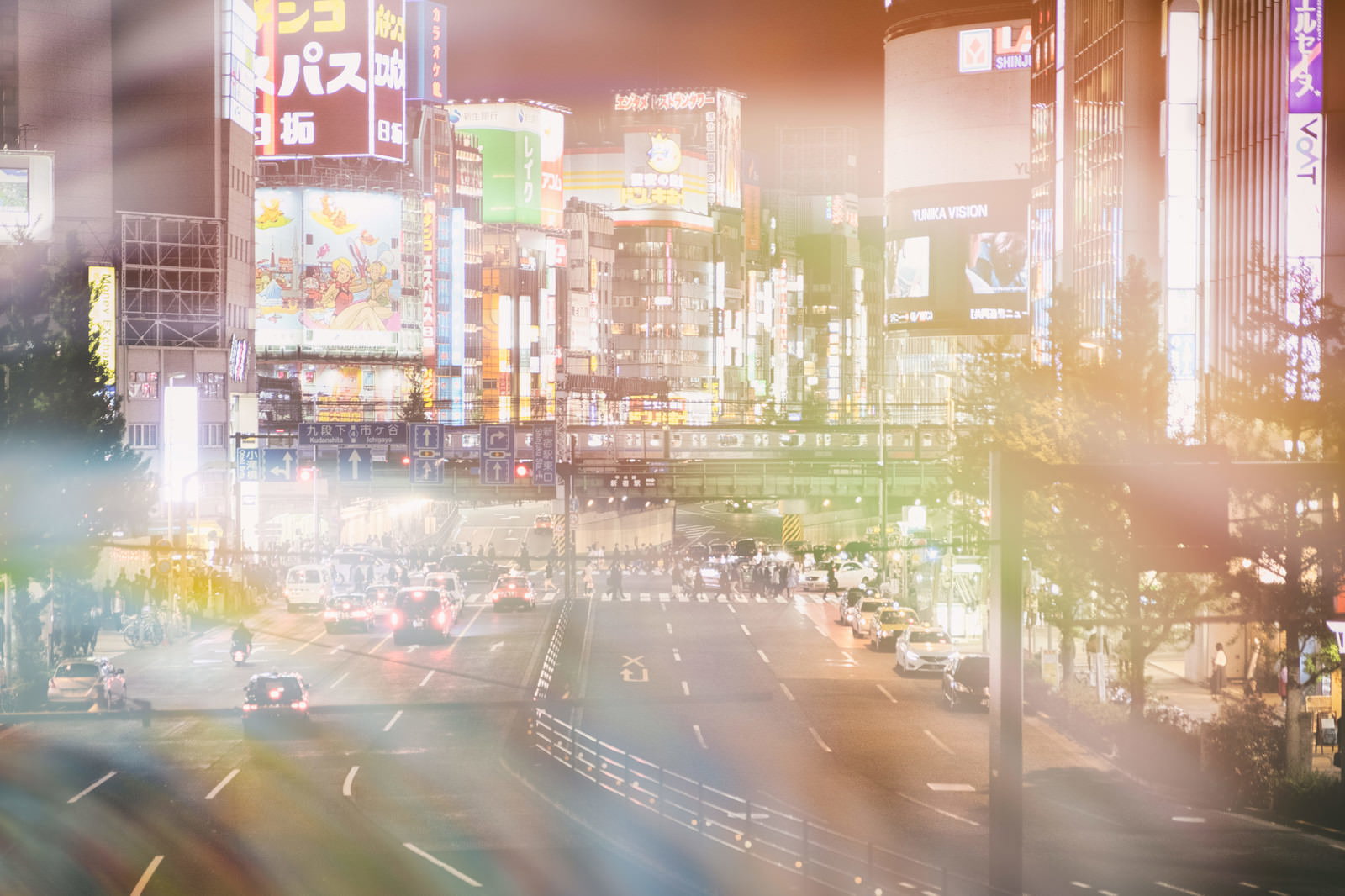 新宿大ガード越しに見る繁華街のネオン光がフォトモンタージュ効果で重なる夜景