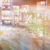 新宿大ガード越しに見る繁華街のネオン、フォトモンタージュで重なる夜景の写真