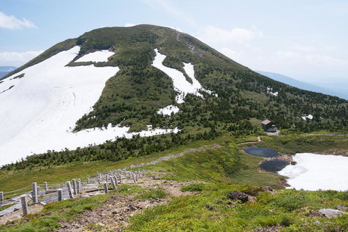 残雪の八甲田大岳と山小屋、初夏の登山道を歩く風景