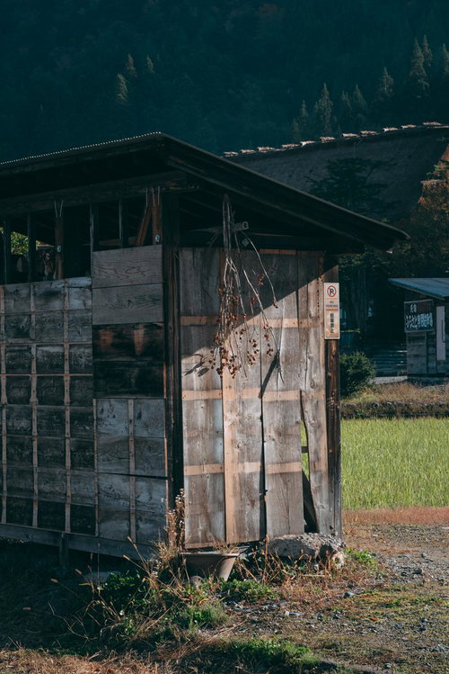白川郷の古びた木造納屋と農村風景、合掌造りの伝統建築