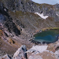 初夏の焼岳山頂に浮かぶエメラルドグリーンの火口湖の写真