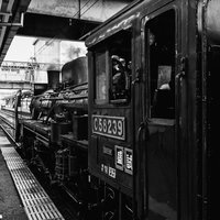 駅のホームに停車中の蒸気機関車（モノクロ）の写真