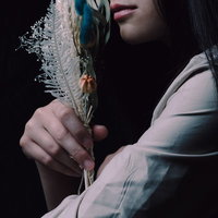 ドライフラワーのスワッグを手に取る女性の横顔の写真
