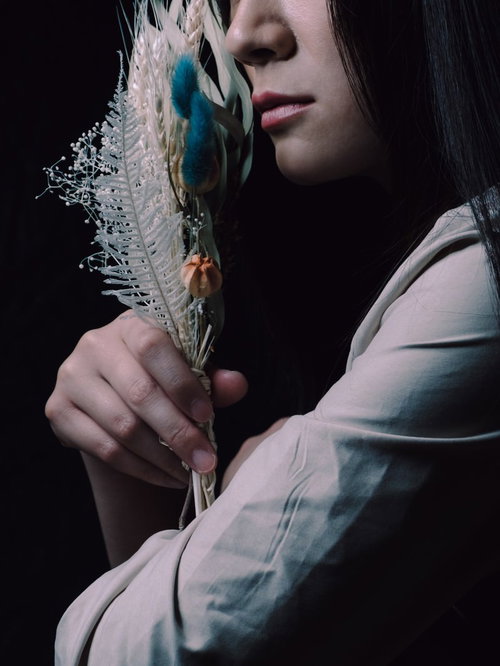 ドライフラワーのスワッグを手に取る女性の横顔