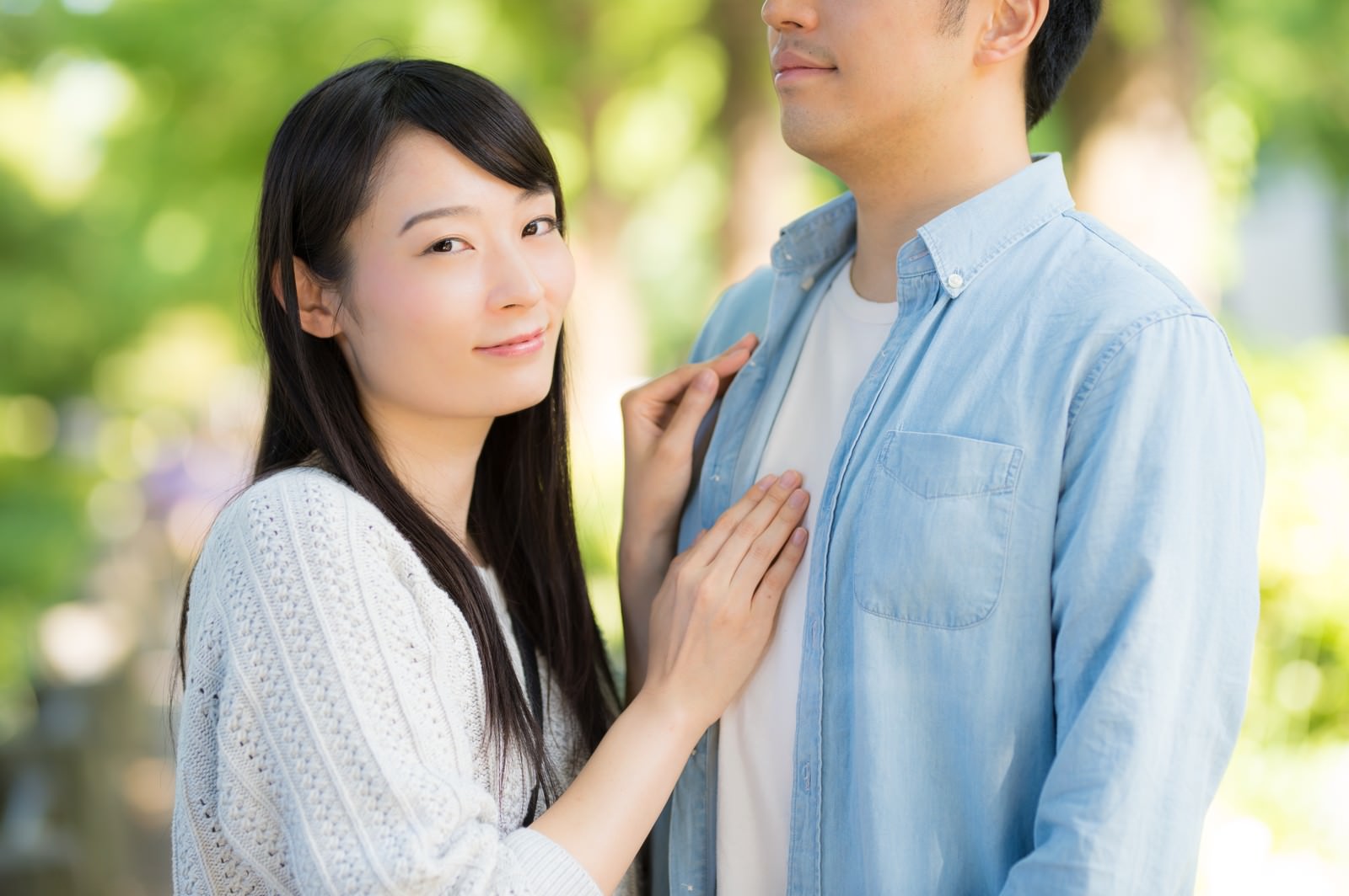 男性の胸元に手を添えて寄り添う女性と男性のカップル［モデル：たけべともこ］
