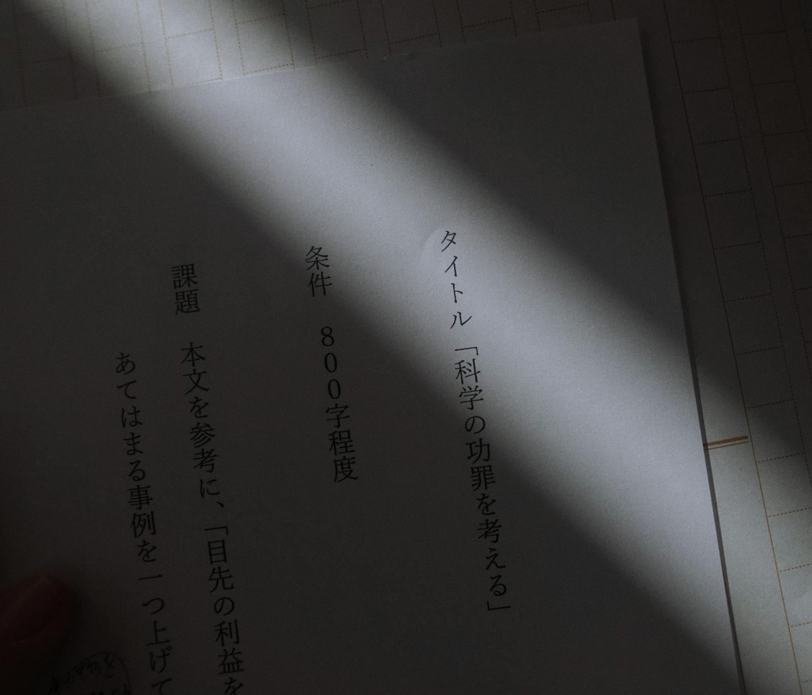 原稿用紙に手書きされた作文課題「科学の功罪を考える」のテキスト