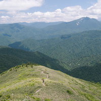 平ヶ岳の登山道から見渡す尾根と谷を交えた広大な自然の写真