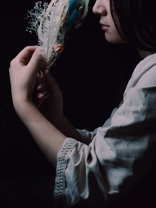 白いブラウスを着た女性がスワッグに手を添える手元