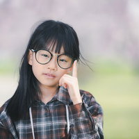 チェックシャツを着た眼鏡クイで軽蔑する女の子の写真