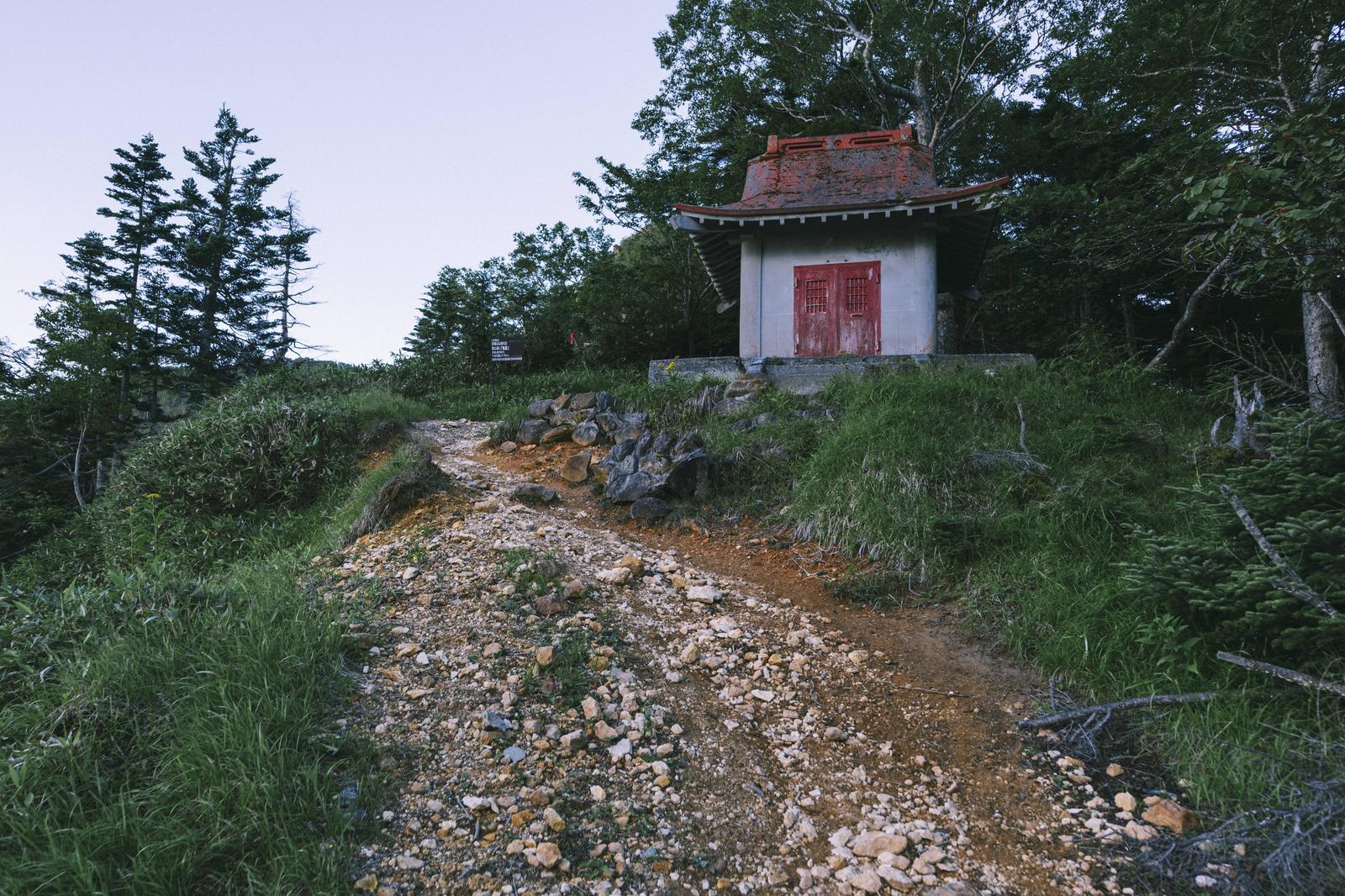 金精峠の赤い扉がついた白い社と登山道