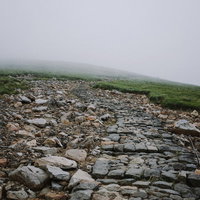 鳥海山の石段登山道を覆う濃い霧とガス中での登山風景の写真