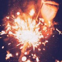 夜空に激しくスパークする手持ち花火の火花と光の写真