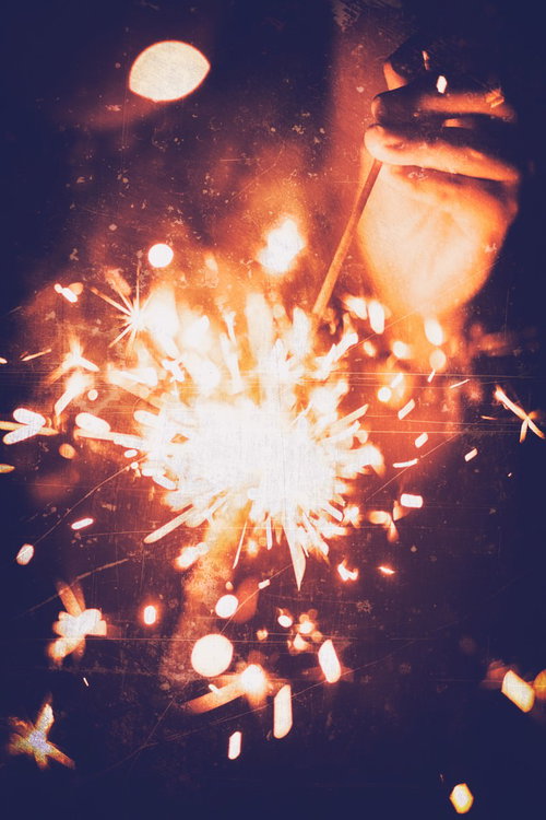 夜空に激しくスパークする手持ち花火の火花と光