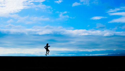 気分が舞い上がって飛び上がる女性のシルエット
