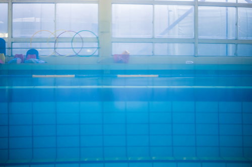 プールサイドの青い水面と屋内プール施設の清潔な空間