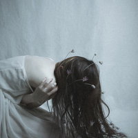 絶望で前屈みに蹲る女性モデル、頭を抱えてストレスを表現の写真