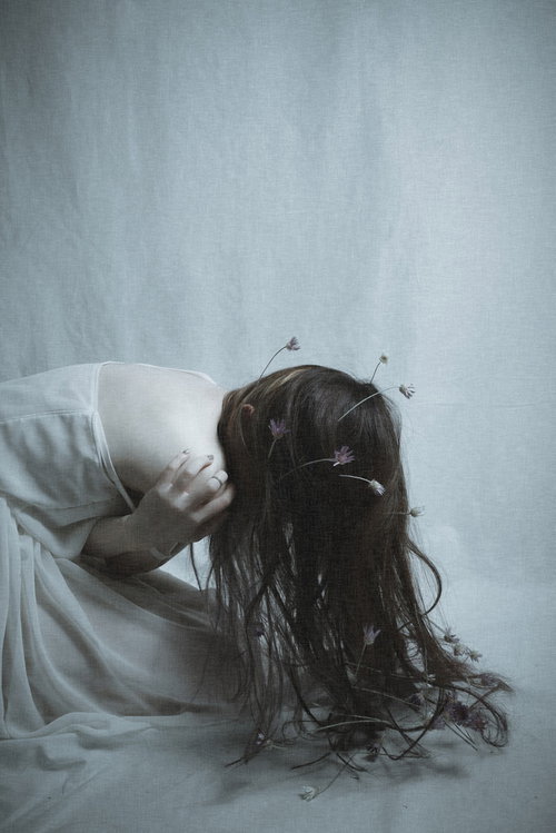 絶望で前屈みに蹲る女性モデル、頭を抱えてストレスを表現