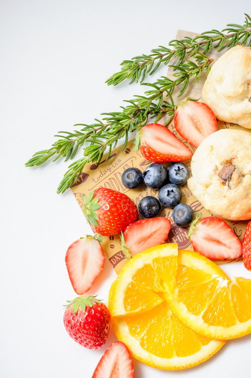 まな板に並べたカットフルーツとスコーンの朝食