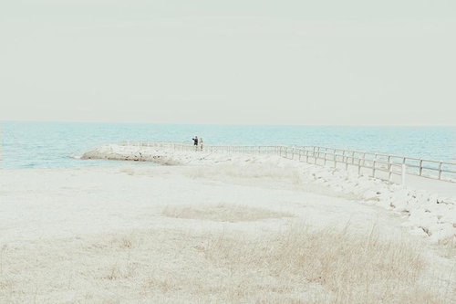 伊勢市二見興玉神社の浜辺から望むカップルと水平線