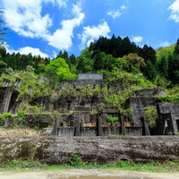 緑に囲まれた山間部に残る土倉鉱山跡の廃墟の写真