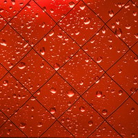 赤く染まる外と窓の水滴が光に輝く透明感のあるテクスチャの写真