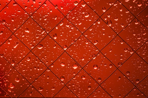 赤く染まる外と窓の水滴が光に輝く透明感のあるテクスチャ