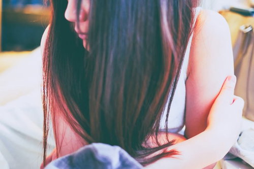 少しだけ肌寒い女性の冷房対策、手で口元を覆う