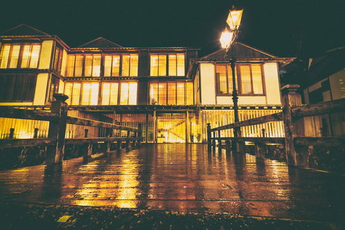 銀山温泉の夜間、ガス灯に照らされたレトロな木製の橋