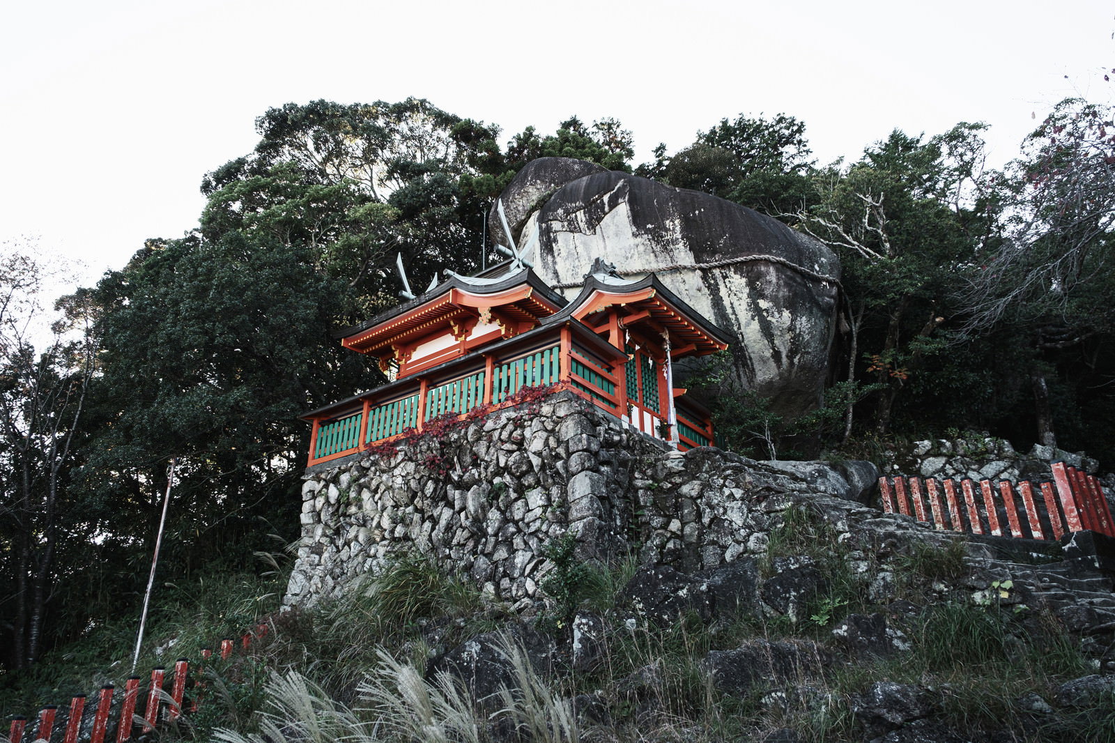 神倉神社の境内で赤い拝殿の背後にそびえ立つ巨石ゴトビキ岩