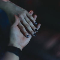 暗闇で交わす二人の手に映る絆と親密なふれあいの写真