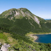 五色沼と日光白根山の登山風景、岩肌と高山湖の山岳景観の写真