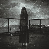 屋上フェンス越しに立つゴースト女性のシルエットの写真