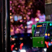 イルミネーションのキラキラと公衆電話の写真