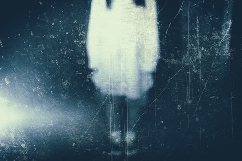 暗闇にボンヤリと写る白い衣装の女性の姿（フィルム）