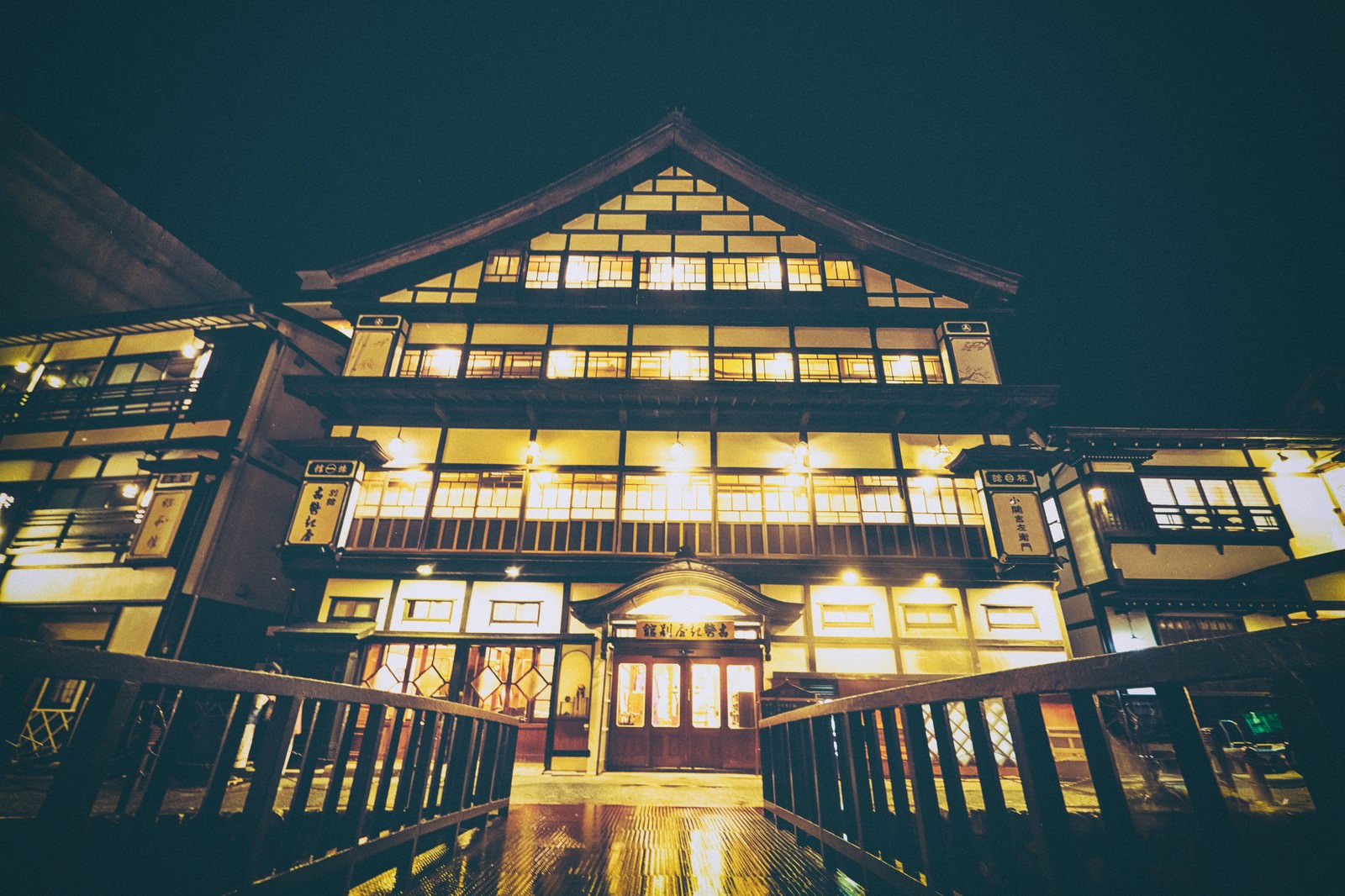 雪に覆われた銀山温泉街の夜景、温かな灯りが灯る木造旅館群