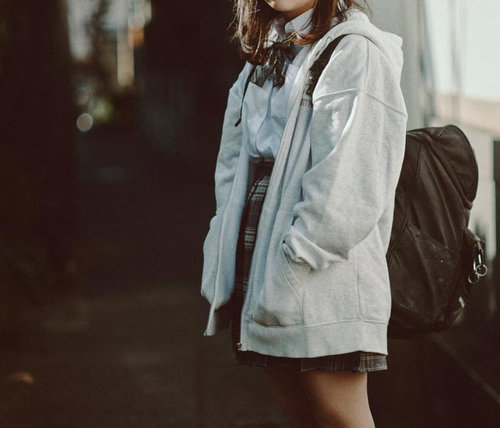 放課後の下校途中に立ち止まる女子高生