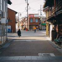 下町の古い住宅街を抜ける通り、電柱と看板のある昭和レトロな町並みの写真