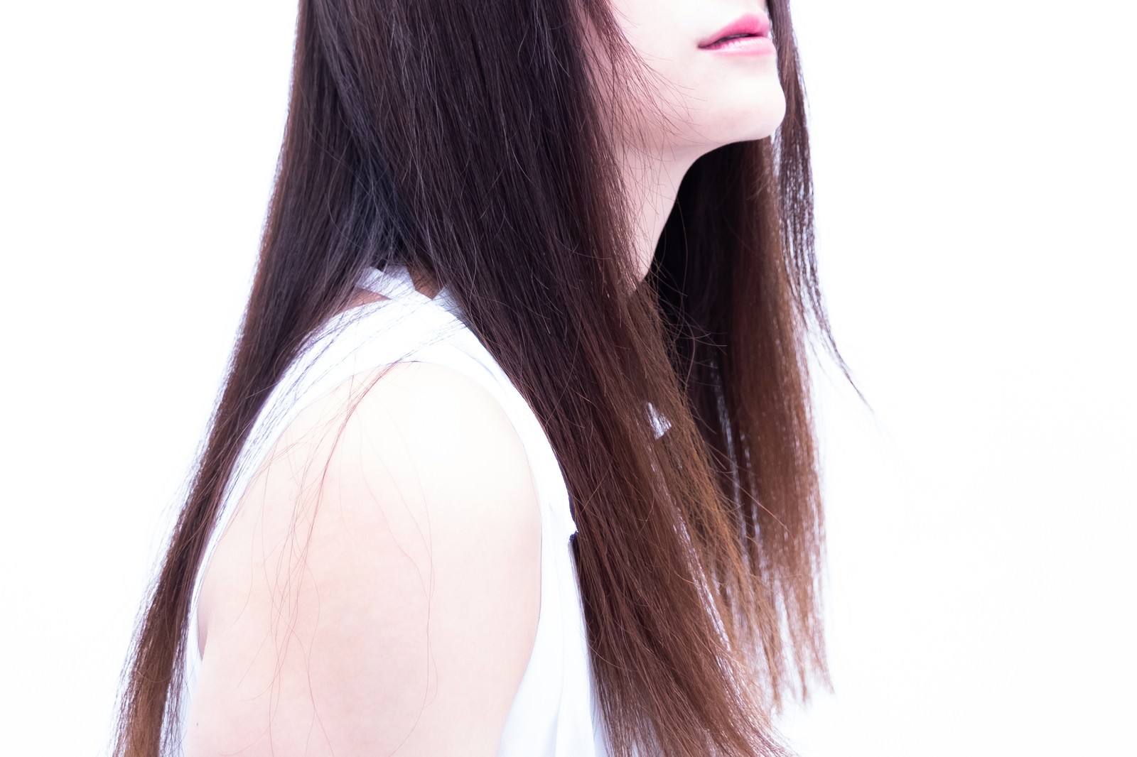 つややかなロングヘアの女性が横顔を向いている様子