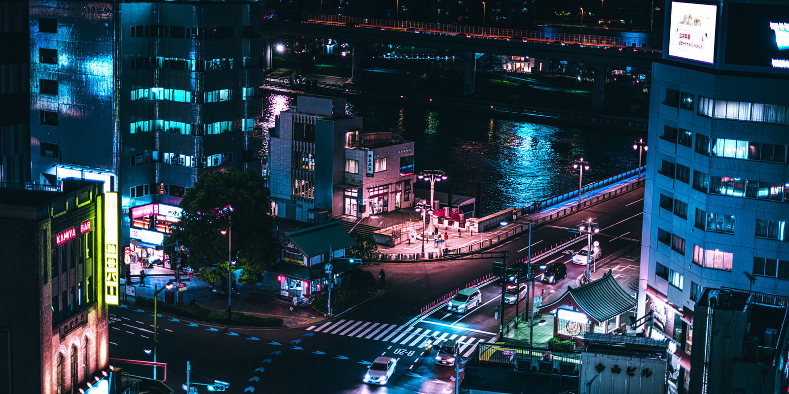 夜の隅田川沿いに立ち並ぶ高層ビルと橋梁がネオンに照らされた都市夜景