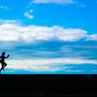 気分は上々でスキップする女性のシルエットの写真