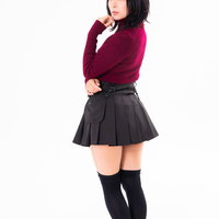 赤いトップスにハイソックスで振り返りざまのポージングの写真