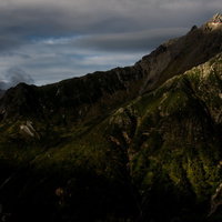 夕日に照らされる槍ヶ岳と西鎌尾根の北アルプス山稜の写真
