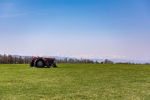 美ヶ原高原の緑の草原に置かれた赤いトラクター