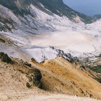 馬の背から見下ろす安達太良山の爆裂火口と硫黄鉱物の写真