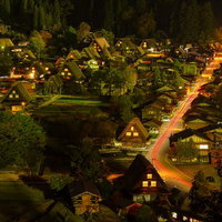 白川郷の夜景、合掌造りの集落を彩る光跡と茅葺屋根の民家群の写真