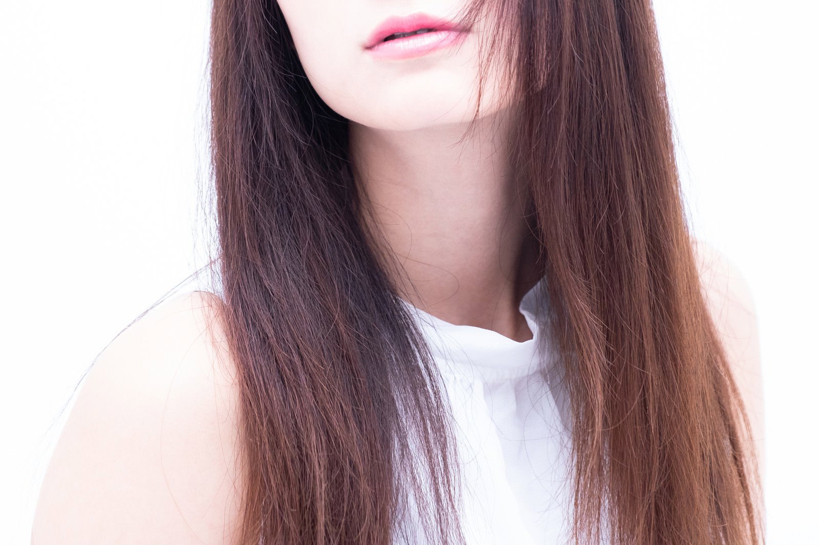 Close-up of a woman's lips and brown long hair wearing white clothes