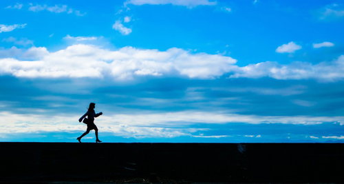 足で稼ぐ女性営業マン、埠頭を歩くシルエット