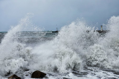 防波堤の消波ブロックに打ち付ける荒波と波飛沫