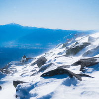 蓼科山冬山山頂の煌めく雪と岩場の絶景の写真